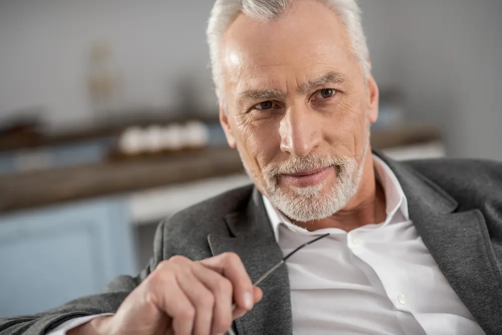 Man holding glasses looking positive
