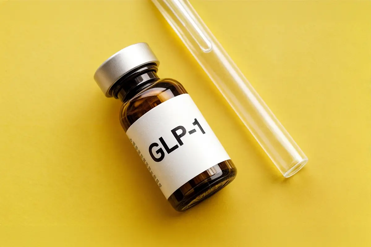 Vial labeled GLP-1 yellow background symbolizing medication